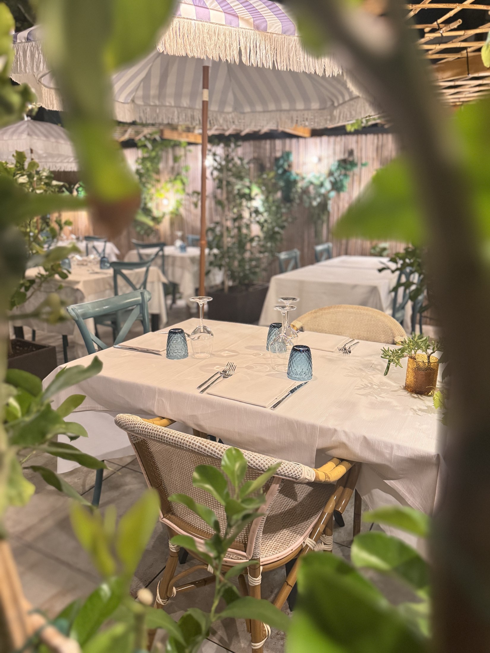 Tavolo apparecchiato nel giardino del Seaside visto attraverso il verde